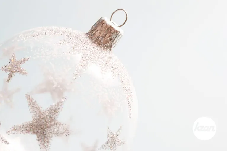 Close up detailf of a Christmas ball ornament against a soft blue background.