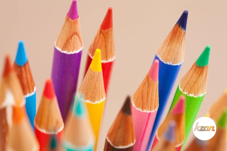 Close up view of a bunch of multiple colored drawing pencils isolated on a plain background.