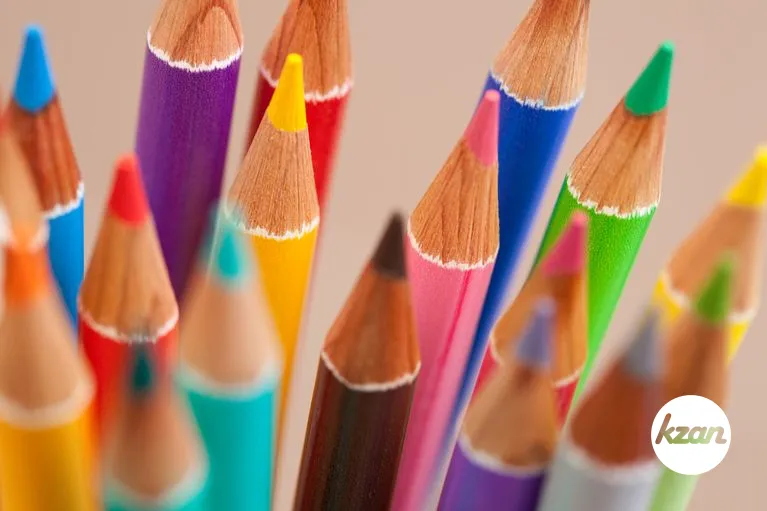 Close up view of a bunch of multiple colored drawing pencils isolated on a plain background.